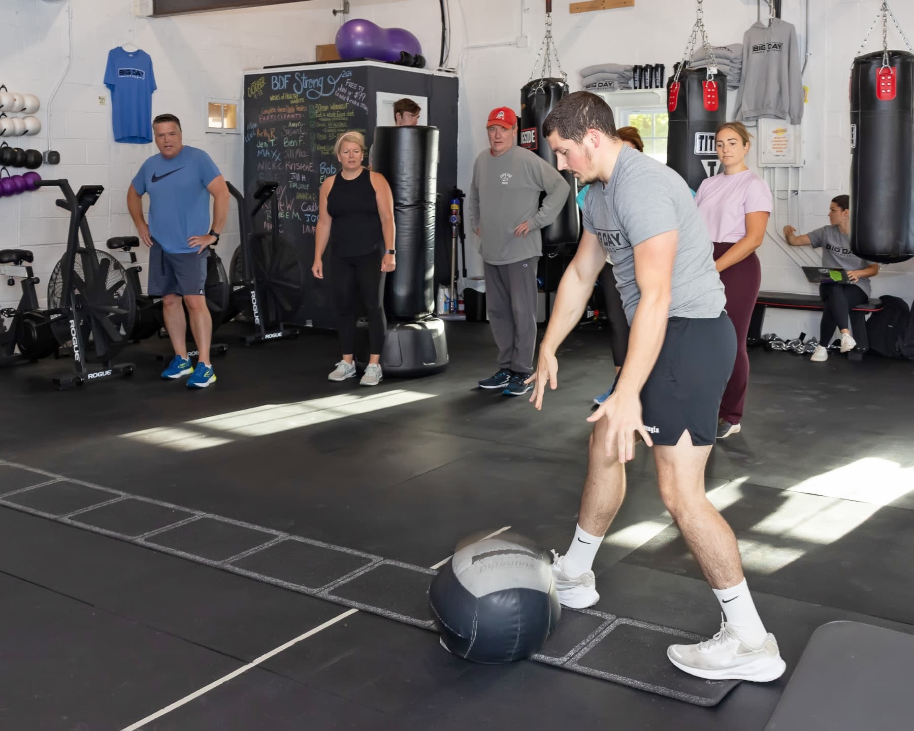 Coach demonstrating a movement to a small group at Big Day Fitness